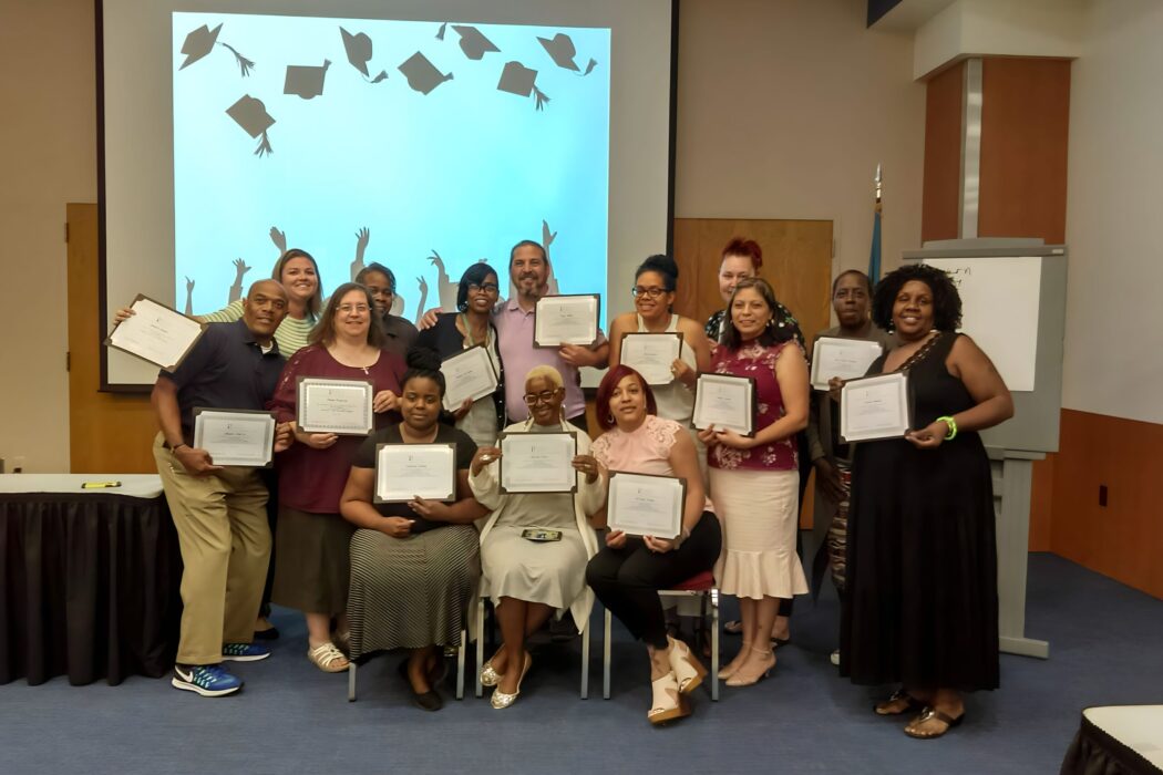 Community health workers (CHWs) celebrating with their certificates after completing a CHW training.