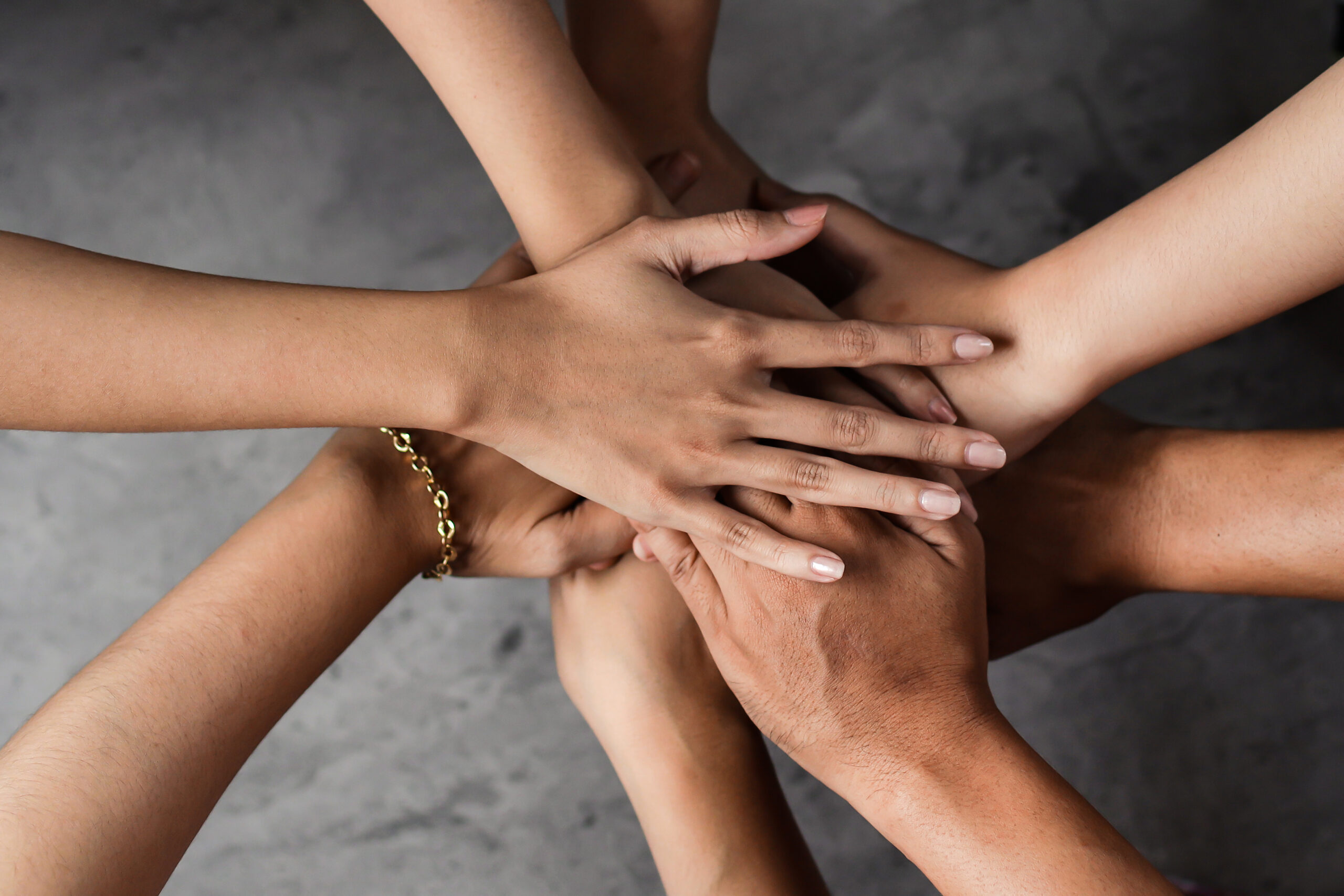 A group of hands coming together.